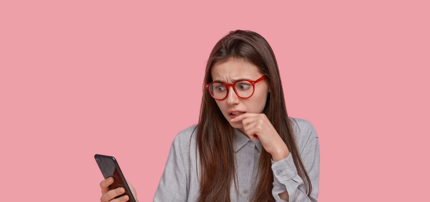 Frustrated displeased woman reads negative news on internet website, connected to wifi, works on dev